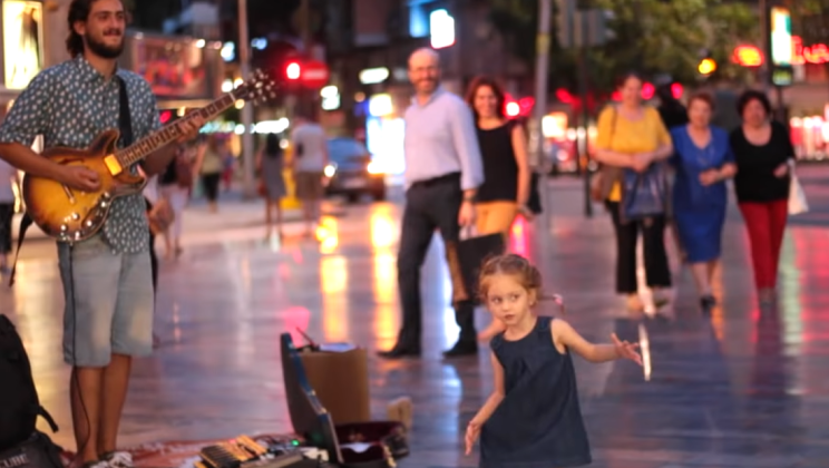 The little girl heard her favorite song while walking with her mother. He left her mother’s hand and ran to dance